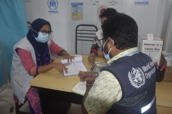 WHO reviews vaccine uptake figures alongside partners at a health facility